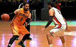 Jagdeep Singh of Mumbai Challengers puts the ball to the floor against Ajay Pratap Singh of Delhi Capitals