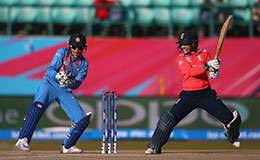 Tammy Beaumont of England hits the ball towards the boundary as Sushma Verma of India looks on during the Womens ICC World Twenty20 India 2016