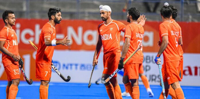 India men's hockey players Manpreet Singh and teammates talk on the pitch during an Asian Games 2026 match