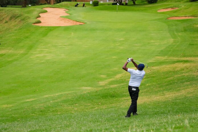 Golfer swinging a club on a green course, representative image for round two of the DP World PGTI Qualifying School Final Stage in Ahmedabad